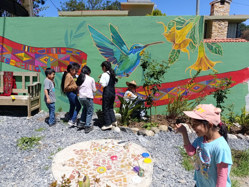 Un grupo de niños en lado de un muralla de una colibri.